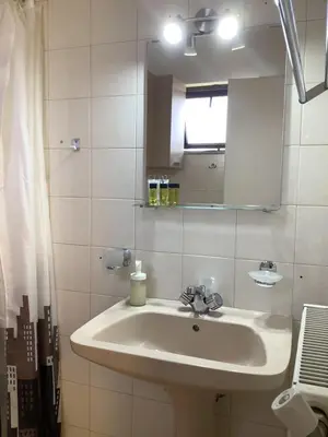 a white bathroom with a sink and a mirror at Piccolo Paradiso Apartments in Kato Daratso