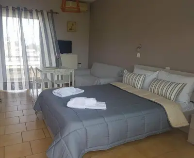 a living room with a bed and a couch at Piccolo Paradiso Apartments in Kato Daratso
