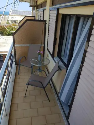 a balcony with two chairs and a table on it at Piccolo Paradiso Apartments in Kato Daratso