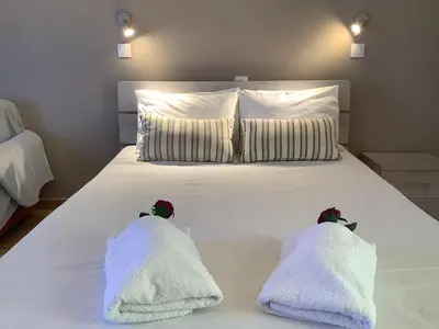 a white bed with two towels on top of it at Piccolo Paradiso Apartments in Kato Daratso