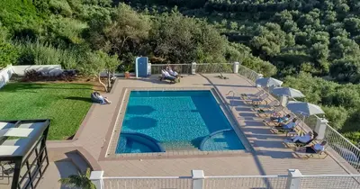 an overhead view of a swimming pool with people sitting around it at Cretan Blu Platanias in Plataniás