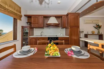a kitchen with a wooden table with a bowl of fruit at Cretan Blu Platanias in Plataniás
