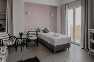 a bedroom with a bed and a table and chairs at Tellus City in Chania Town