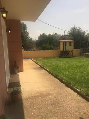a walkway leading to a yard with a house at Maria's Garden in Galatás
