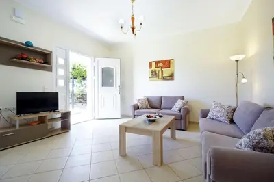 a living room with a couch and a table at Maria's Garden in Galatás