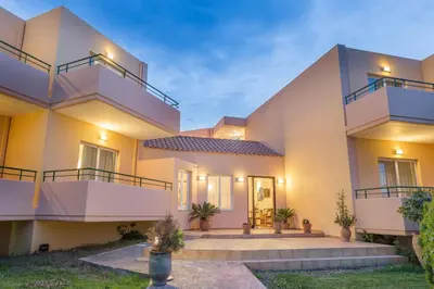 a house with two balconies and a courtyard at Alonia Hotel Apartments in Kolymvari