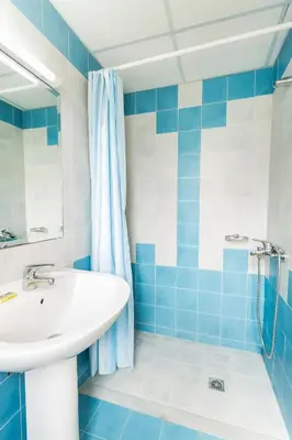 a blue and white bathroom with a sink and a shower at Alonia Hotel Apartments in Kolymvari