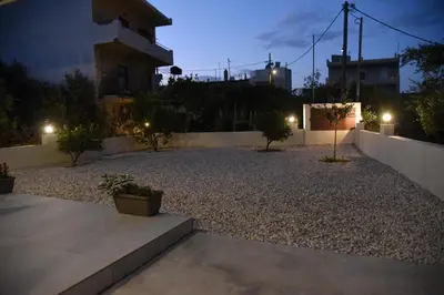 a gravel yard at night with a building at Pirgos Deluxe Apartment - Private Parking in Kissamos