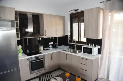 a kitchen with wooden cabinets and a microwave at Pirgos Deluxe Apartment - Private Parking in Kissamos