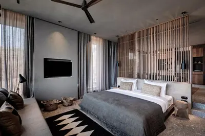 a bedroom with a bed and a flat screen tv at Domes Zeen Chania, a Luxury Collection Resort, Crete in Kato Daratso