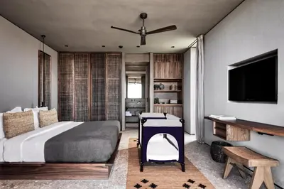 a bedroom with a bed and a flat screen tv at Domes Zeen Chania, a Luxury Collection Resort, Crete in Kato Daratso
