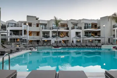 a swimming pool in front of a hotel at Porto Platanias Beach Luxury Selection - Adults Only in Plataniás