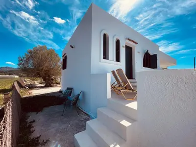a white house with two chairs on the stairs at Brina's House in Kissamos