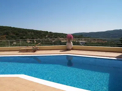a swimming pool with a vase of flowers on a balcony at Villa Rotunda A in Kolymvari
