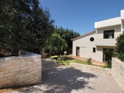 a house with a stone wall next to a building at Villa Rotunda A in Kolymvari