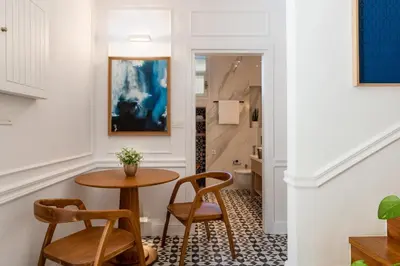 a hallway with a table and chairs and a bathroom at Alexandra's Lighthouse View in Chania Town