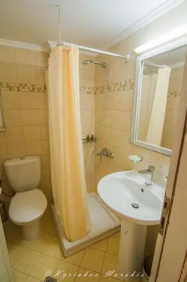 a bathroom with a sink and a toilet and a shower at La Casa Del Vitsi in Palaiochóra