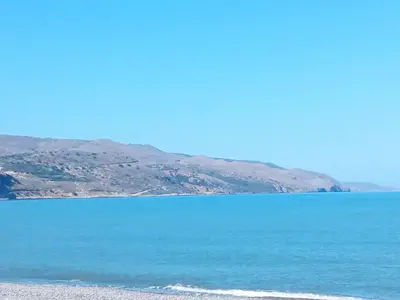 a large body of water with mountains in the background at Mrs Chryssana Beach Hotel in Kolymvari