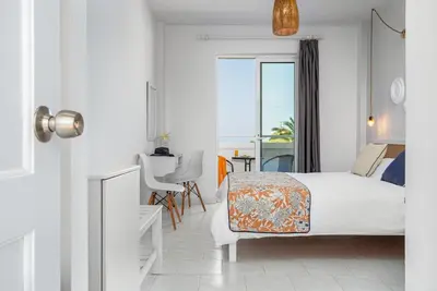 a hotel room with a bed and a view of the ocean at Mrs Chryssana Beach Hotel in Kolymvari