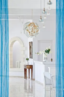 a dining room with a table and a chandelier at Mrs Chryssana Beach Hotel in Kolymvari
