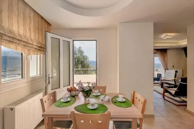 a dining room with a table with green plates at Karmilos Hill Villa in Chania Town