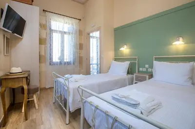 a room with three beds and a desk and a tv at Villa Theta With Private Pool by Amara Living in Drapaniás