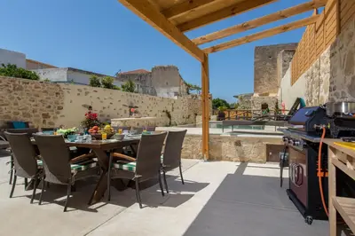 a patio with a table and chairs and a grill at Villa Theta With Private Pool by Amara Living in Drapaniás
