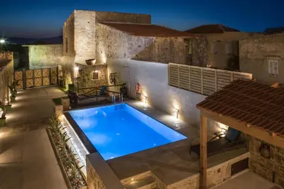 a swimming pool in front of a building at night at Villa Theta With Private Pool by Amara Living in Drapaniás