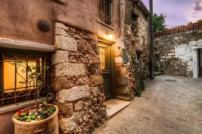 a stone building with a door and a potted plant at Elvie House in Chania Town