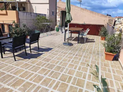a patio with a table and chairs and an umbrella at Elvie House in Chania Town
