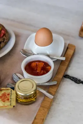 a egg on a plate and a bowl of food at Porto Kalyves Seaside Aparthotel in Kalyves