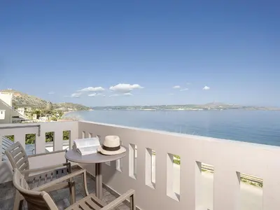 a balcony with a table and chairs and the ocean at Porto Kalyves Seaside Aparthotel in Kalyves
