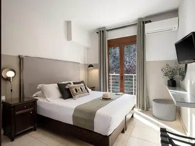 a bedroom with a large bed and a window at Porto Kalyves Seaside Aparthotel in Kalyves