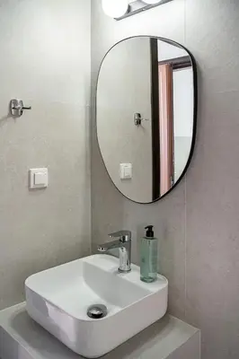 a bathroom with a white sink and a mirror at Porto Kalyves Seaside Aparthotel in Kalyves