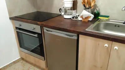 a kitchen counter with a sink and a dishwasher at Green Door Apartment in Chania Town
