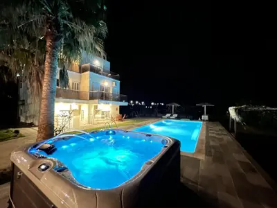 a swimming pool at night next to a building at Martimi Apartments - 200M from Drapanias Beach - Pool - Hot Tub - Sauna - BBQ in Kissamos