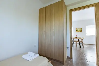 a bedroom with a large wooden cabinet and a table at Martimi Apartments - 200M from Drapanias Beach - Pool - Hot Tub - Sauna - BBQ in Kissamos
