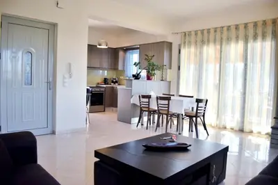 a living room and kitchen with a table and chairs at Almyrida sea view house in Almirida