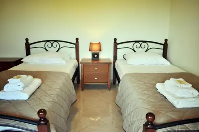two beds in a room with towels on them at Almyrida sea view house in Almirida