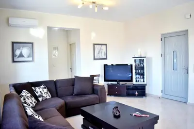 a living room with a couch and a tv at Almyrida sea view house in Almirida