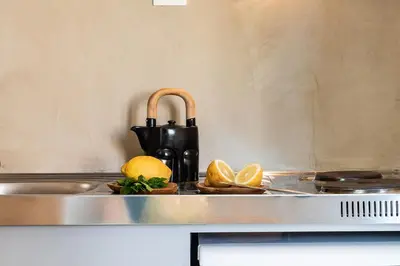 a kitchen counter with a sink with lemons on it at Artemide city places- Petite Apartments in Chania Town