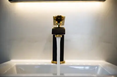 a bathroom sink with a black and gold faucet at Artemide city places- Petite Apartments in Chania Town