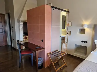 a room with a desk and a room with a bed at Mosaic Venetian Harbour Suites in Chania Town