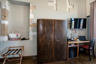a large wooden cabinet in a room with a desk at Mosaic Venetian Harbour Suites in Chania Town