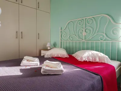 a bedroom with a purple bed with towels on it at Marianos Apartments in Kissamos