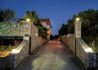 a stone wall with a gate and a road at Marianos Apartments in Kissamos