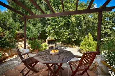 a patio with a table and chairs and a grill at Villa Seli in Gerani Chanion
