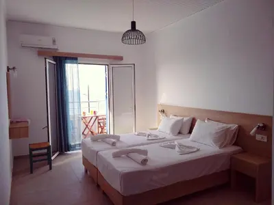 a bedroom with a large bed with a large window at Calypso in Agia Roumeli