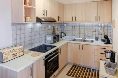 a kitchen with wooden cabinets and a sink at Seashore Apartments in Chorafakia