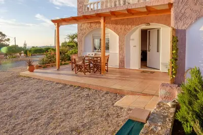 a patio with a table and chairs on a house at Seashore Apartments in Chorafakia